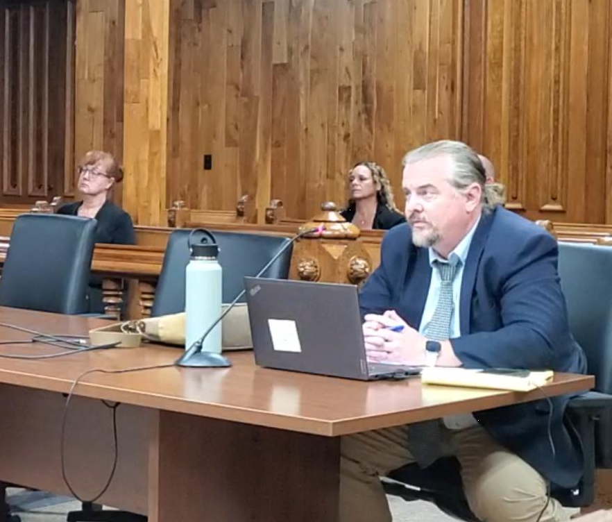 Swanson with Stancil and Hobbs sitting in the back ground